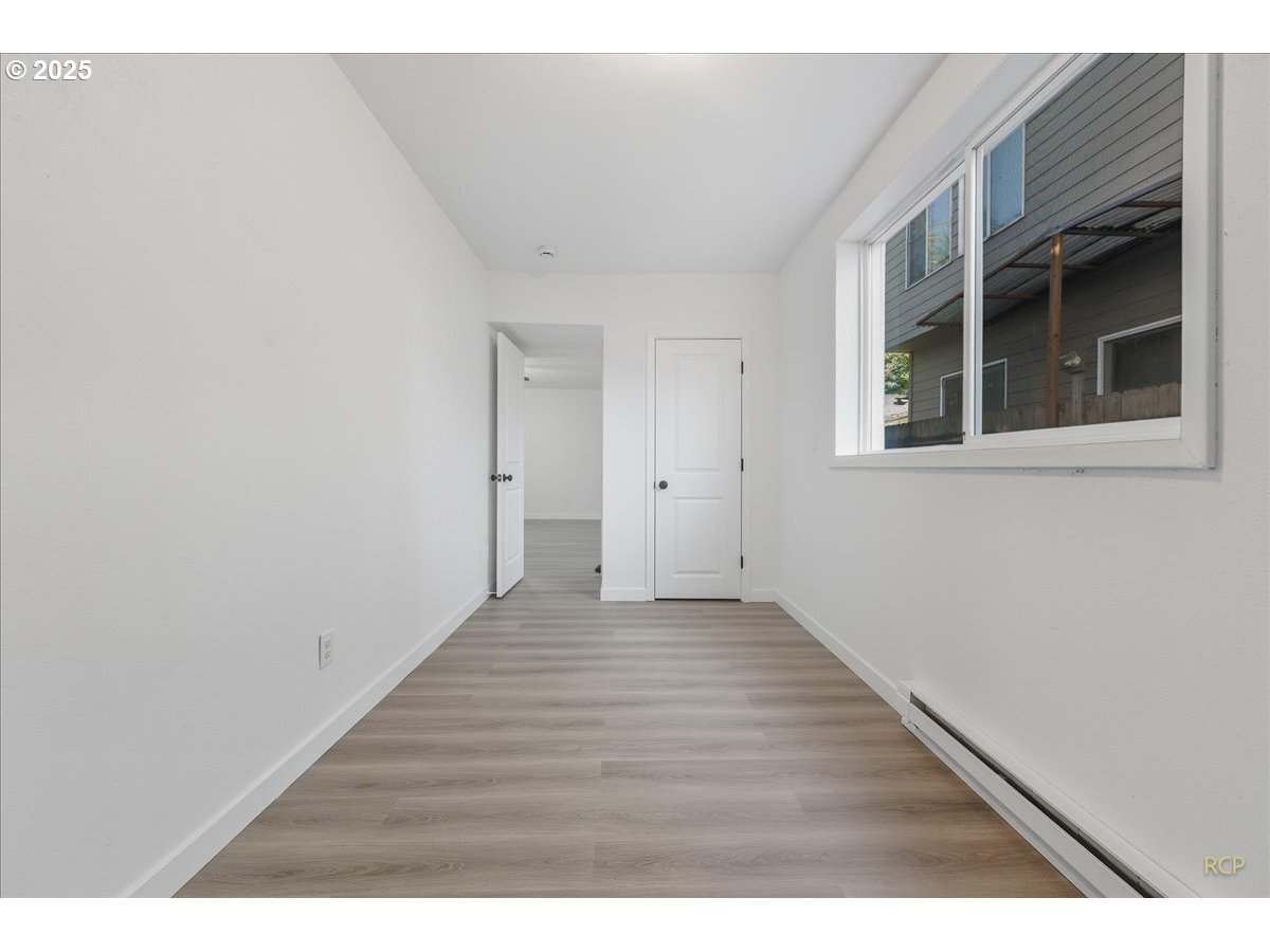 11420 Southeast Clinton Street Portland, OR 97266 - Photo 21 of 34 a view of an empty room with wooden floor and a window