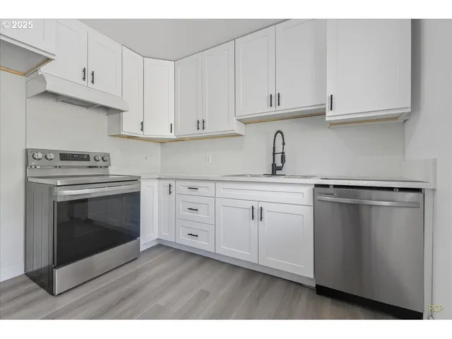 a kitchen with white cabinets and appliances