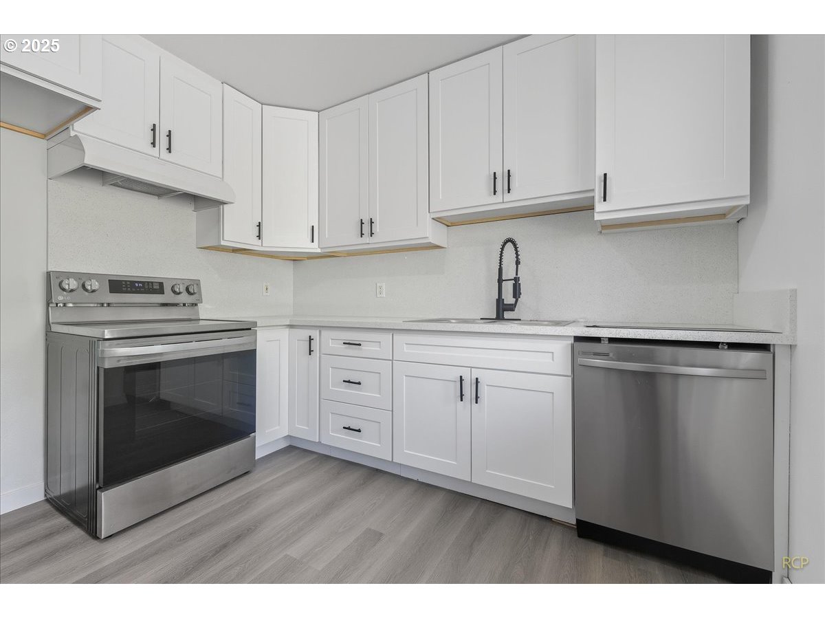 11420 Southeast Clinton Street Portland, OR 97266 - Photo 6 of 34 a kitchen with white cabinets and appliances