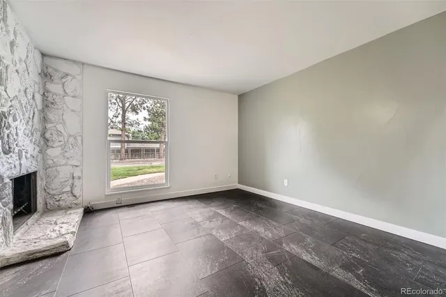 a view of an empty room with a fireplace and a window