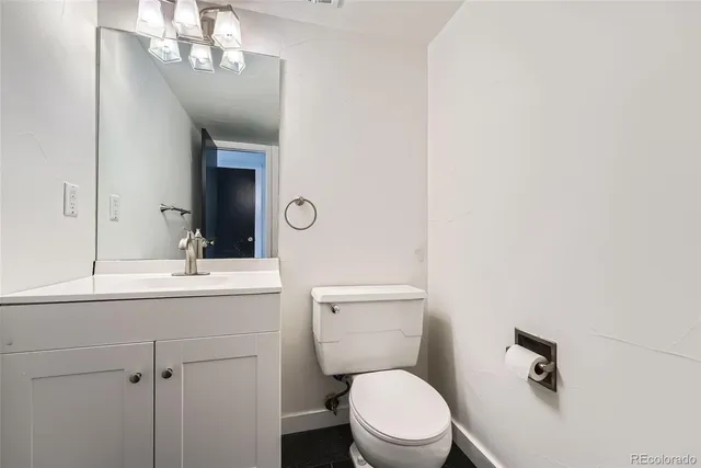 a bathroom with a toilet a sink and mirror