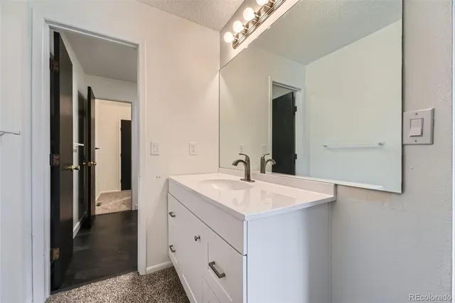 a bathroom with a sink a light fixture and a mirror