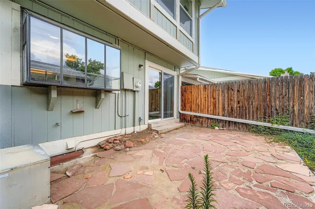 a view of backyard with tub and wooden fence