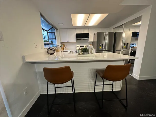 a kitchen with a dining table chairs and a sink