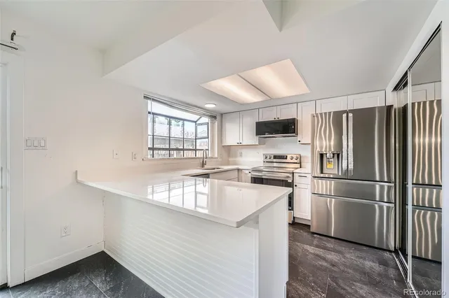 a kitchen with stainless steel appliances granite countertop a refrigerator sink and stove