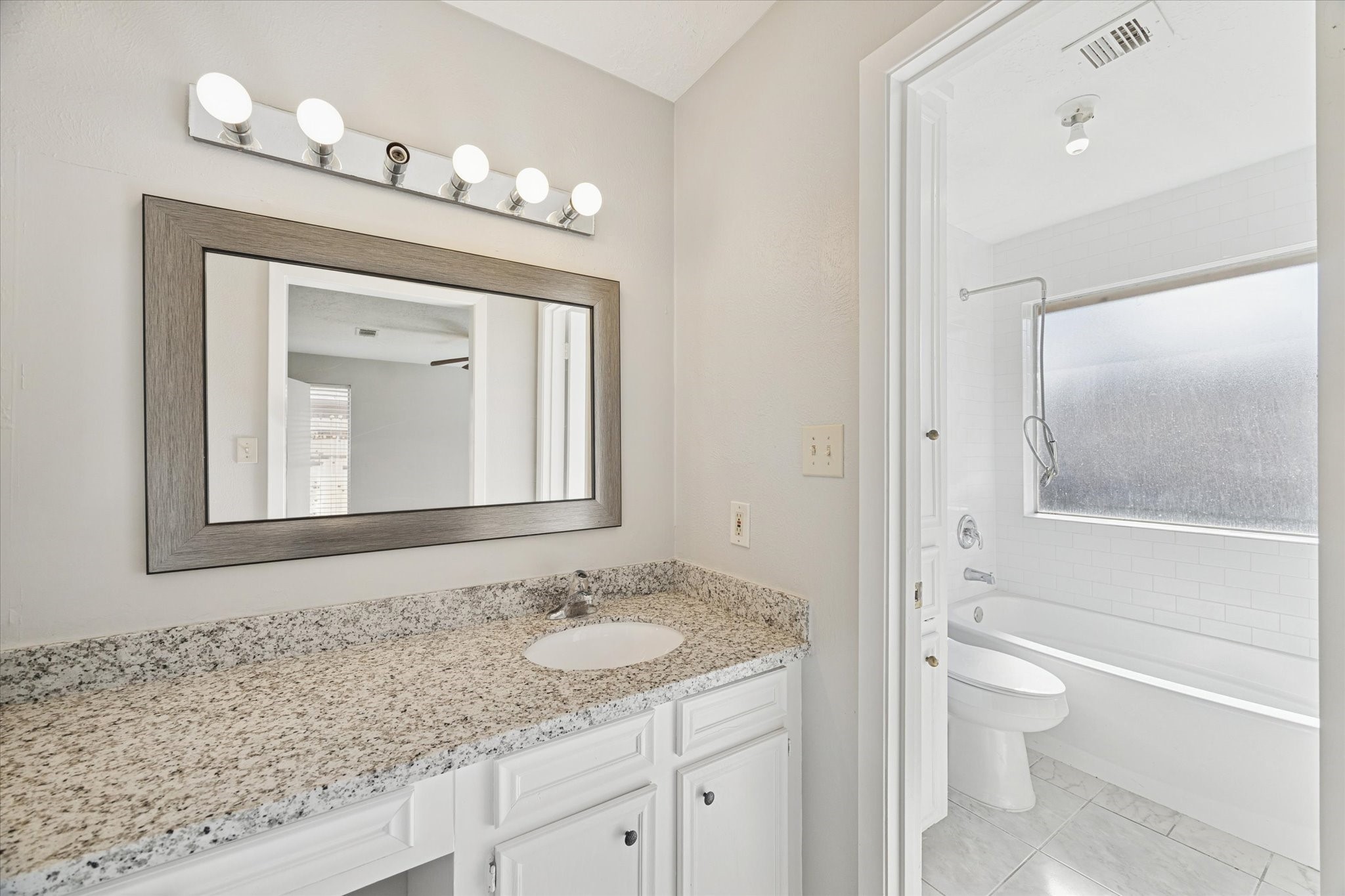 25903 Long Hill Lane Spring, TX 77373 - Photo 14 of 20 a bathroom with a granite countertop sink a toilet and a mirror