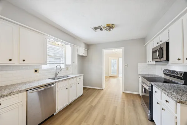 a kitchen with a sink stove and cabinets