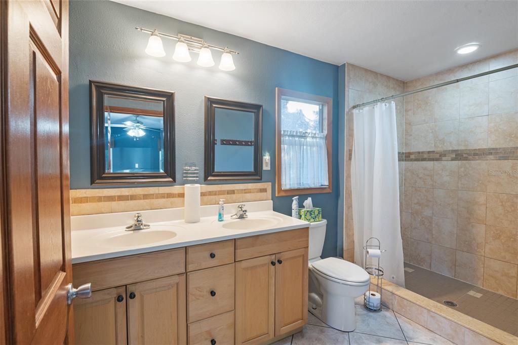 10620 Fawn Drive New Port Richey, FL 34654 - Photo 7 of 49 a bathroom with a double vanity sink toilet and shower