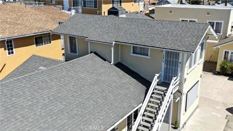 a front view of a house with stairs and wooden fence
