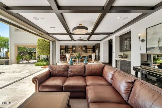 a kitchen with stainless steel appliances granite countertop a stove top oven a sink a dining table and chairs with wooden floor