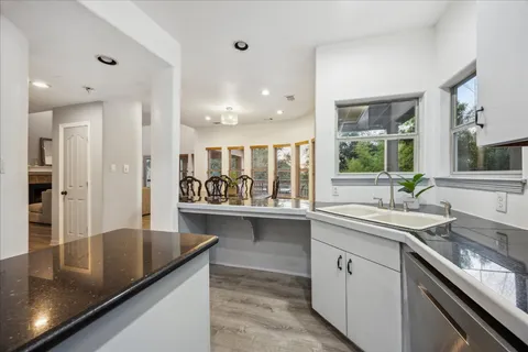 a kitchen with stainless steel appliances granite countertop a sink and a stove