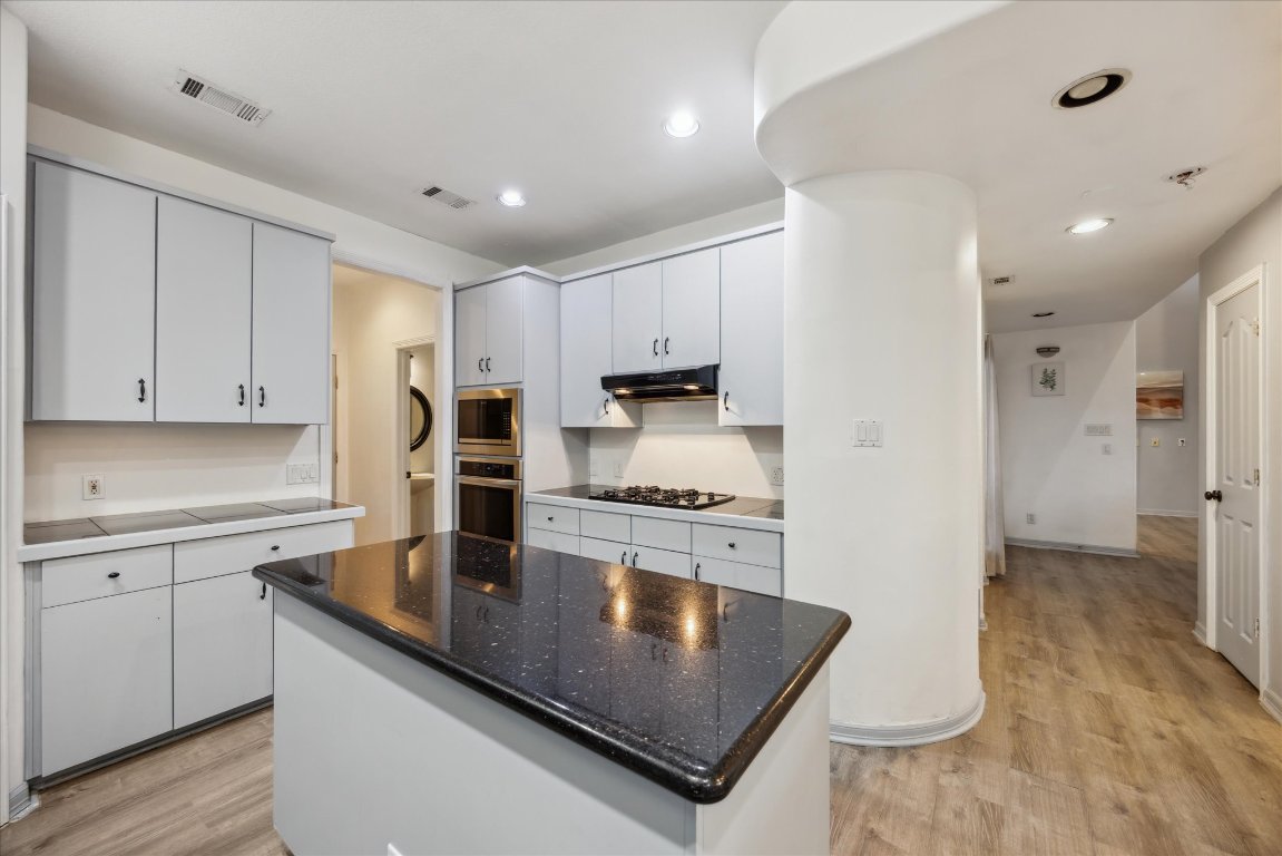 602 Jessie Street Austin, TX 78704 - Photo 12 of 32 a kitchen with stainless steel appliances granite countertop a sink refrigerator and cabinets