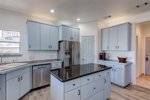 a kitchen with a sink stainless steel appliances and cabinets