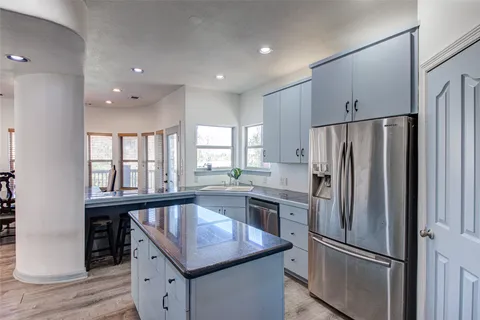 a kitchen with stainless steel appliances granite countertop a refrigerator a sink and a refrigerator