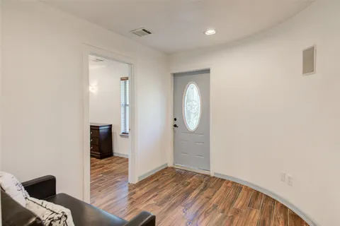 an empty room with wooden floor and mirror