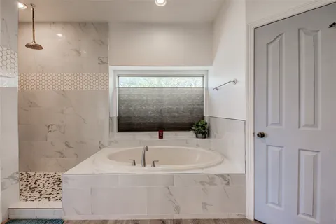 a bathroom with a bathtub and shower