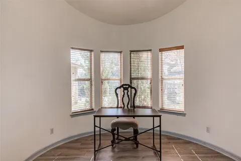 a view of a work space with wooden floor and a window