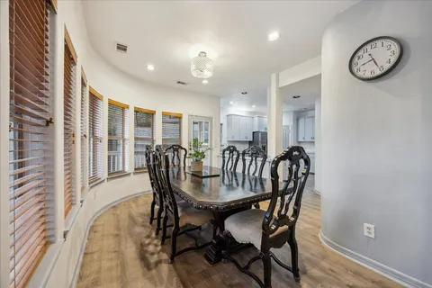 a view of a dining room with furniture clock and wooden floor
