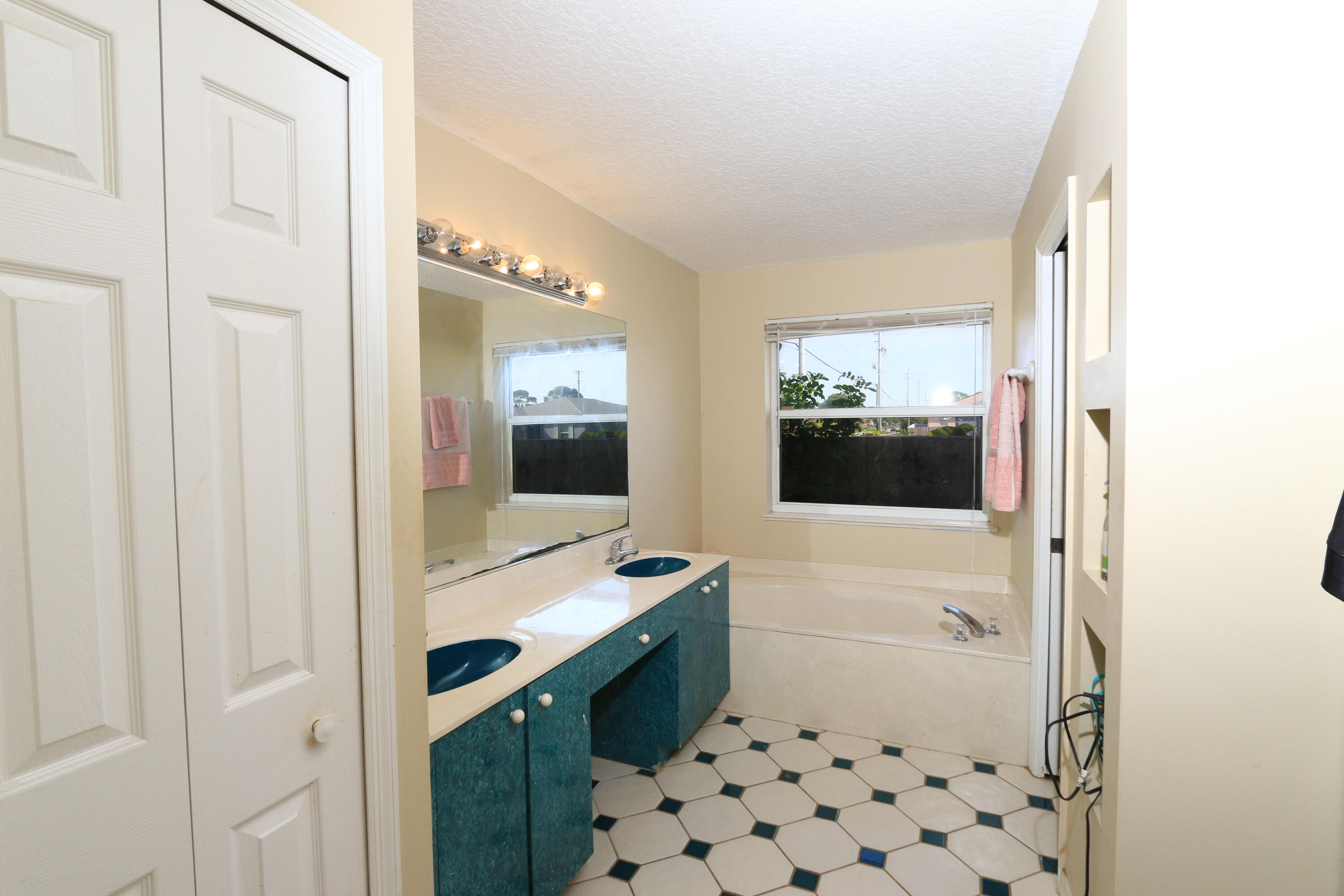 786 Southwest Bond Road Port St. Lucie, FL 34953 - Photo 14 of 33 a bathroom with a sink a mirror and a shower