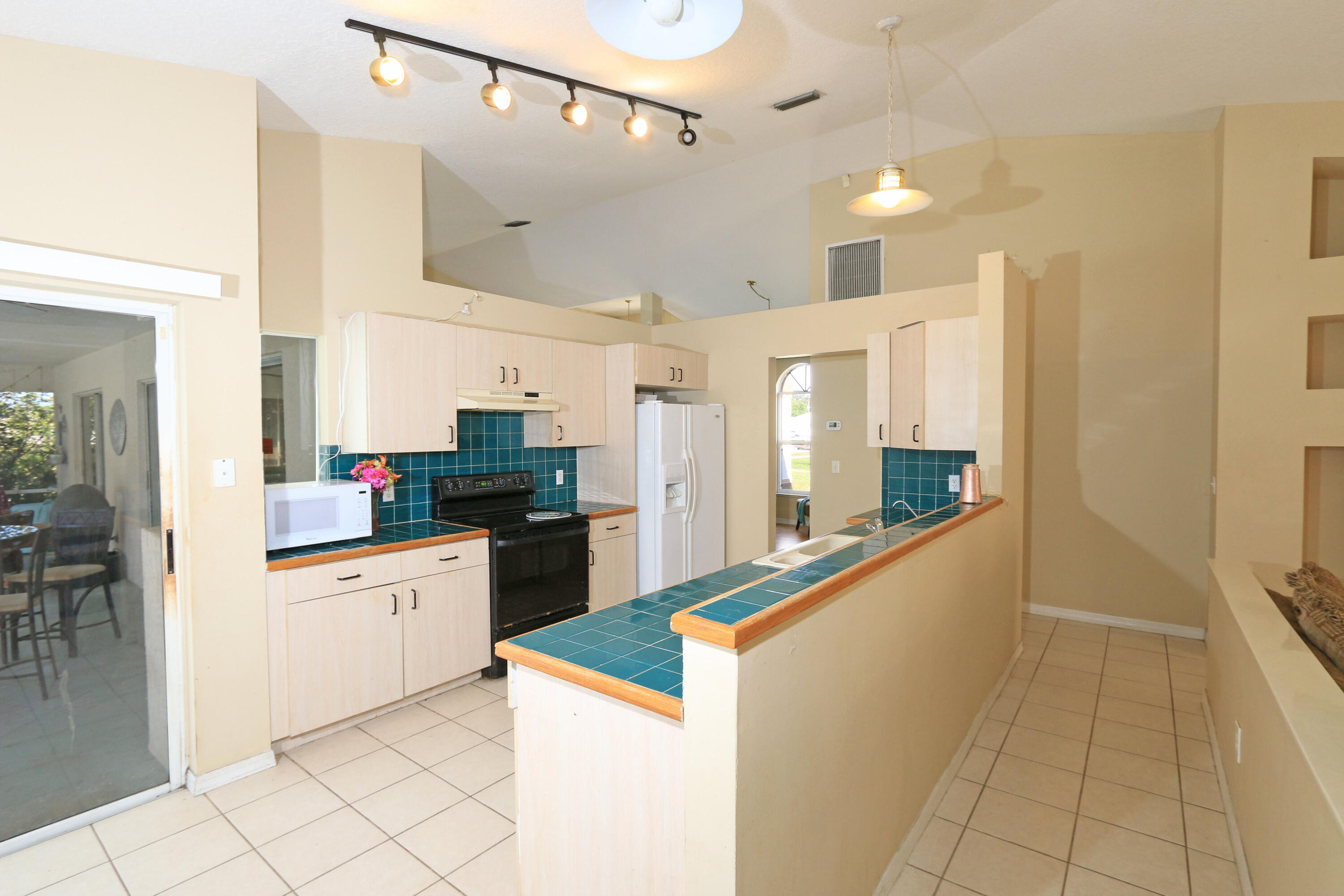 786 Southwest Bond Road Port St. Lucie, FL 34953 - Photo 6 of 33 a kitchen with granite countertop a refrigerator and a sink