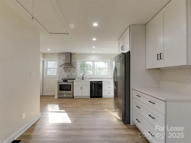 a kitchen with stainless steel appliances a refrigerator and a stove top oven