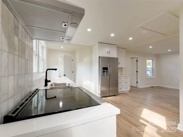 a kitchen with stainless steel appliances a refrigerator sink and cabinets