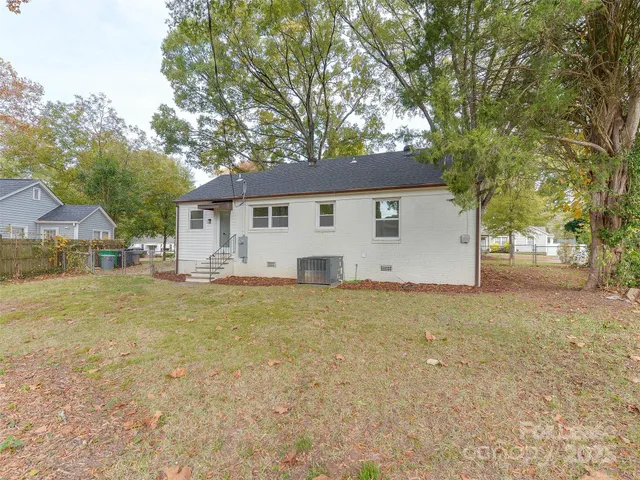 a front view of a house with a garden and trees