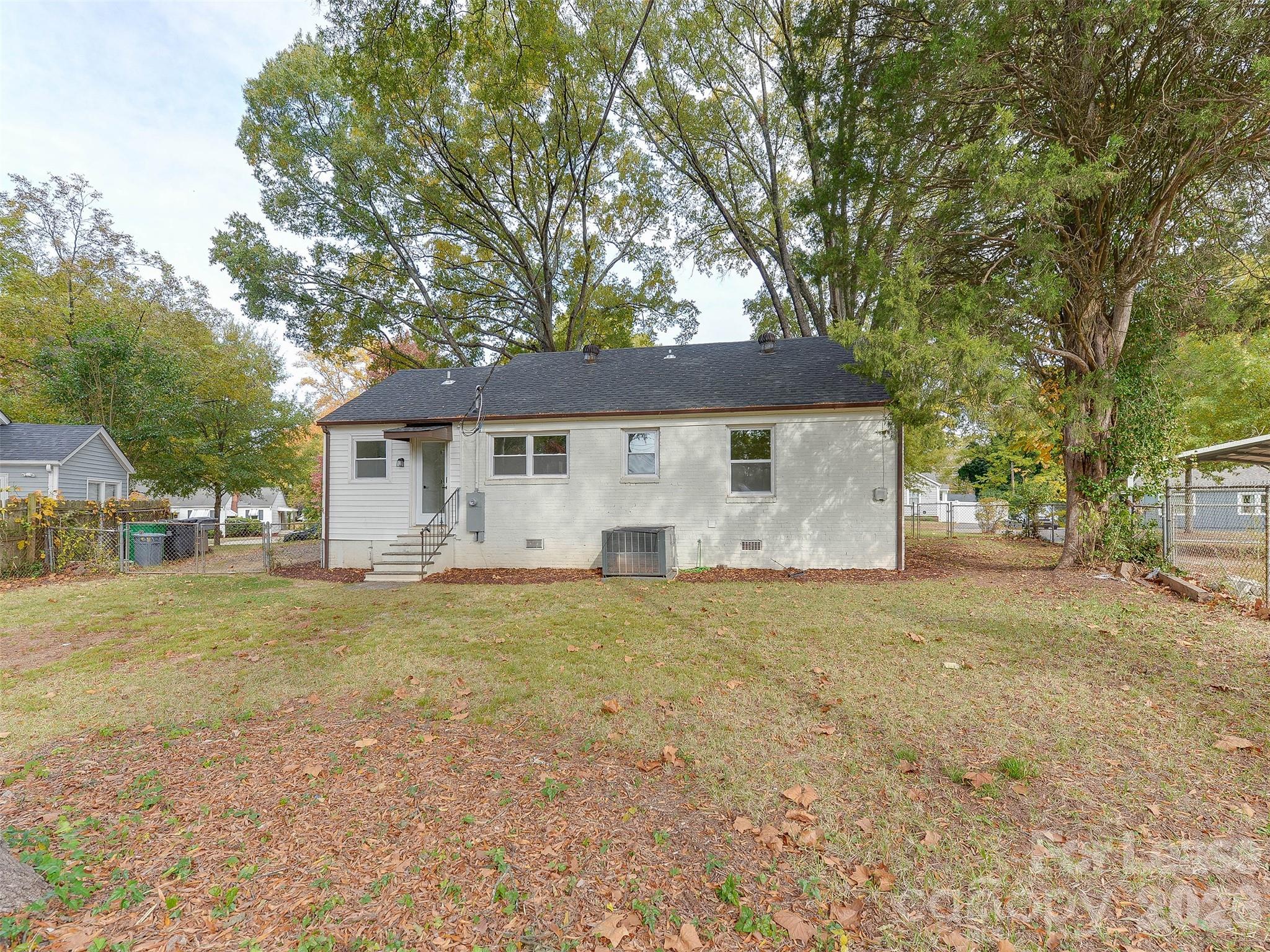 2721 Mayflower Road Charlotte, NC 28208 - Photo 37 of 42 a front view of a house with a garden and trees