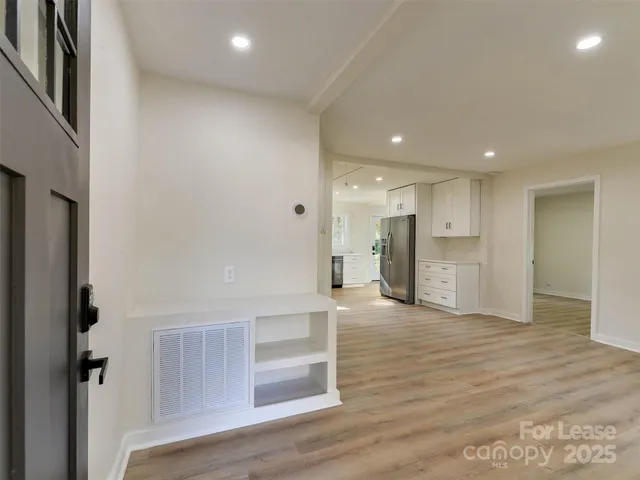 a view of a big room with wooden floor and windows