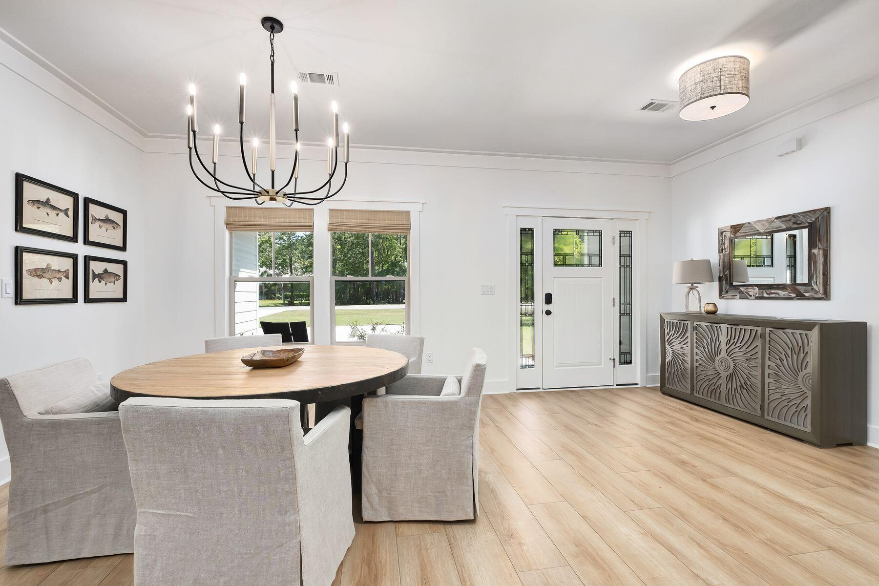 716 Bay Grove Road Freeport, FL 32439 - Photo 6 of 46 a dining room with wooden floor a chandelier a wooden table and chairs