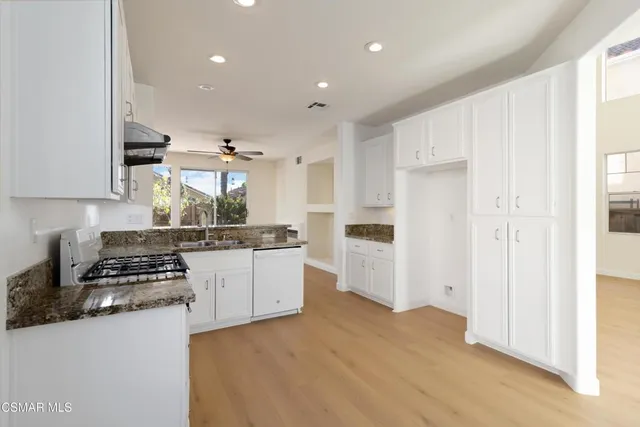 a kitchen with kitchen island granite countertop a stove and a refrigerator