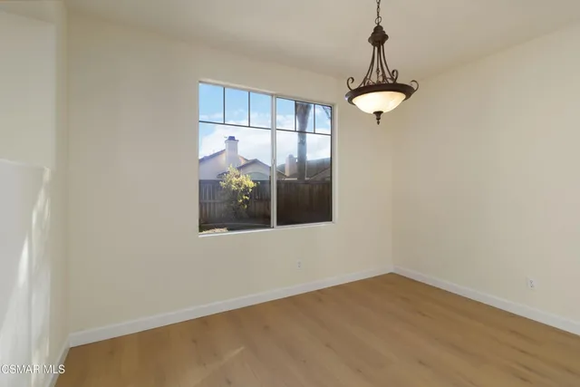 a view of a room with a large window and wooden floor