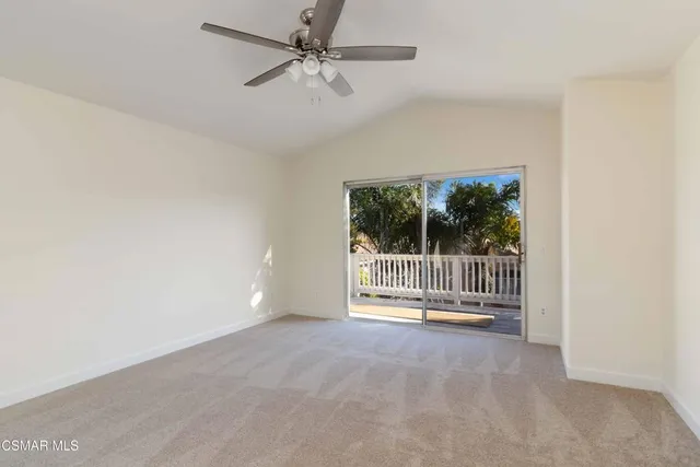 an empty room with fan and windows
