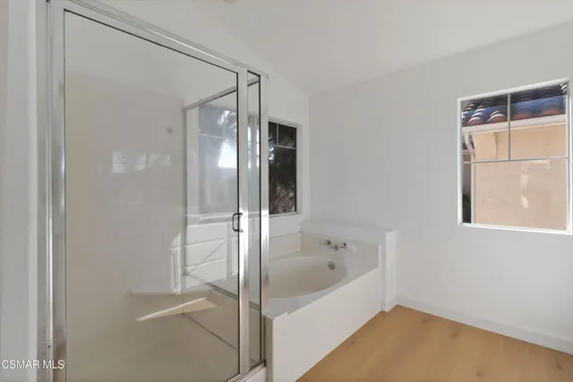 a bathroom with a double vanity sink a mirror and a bathtub