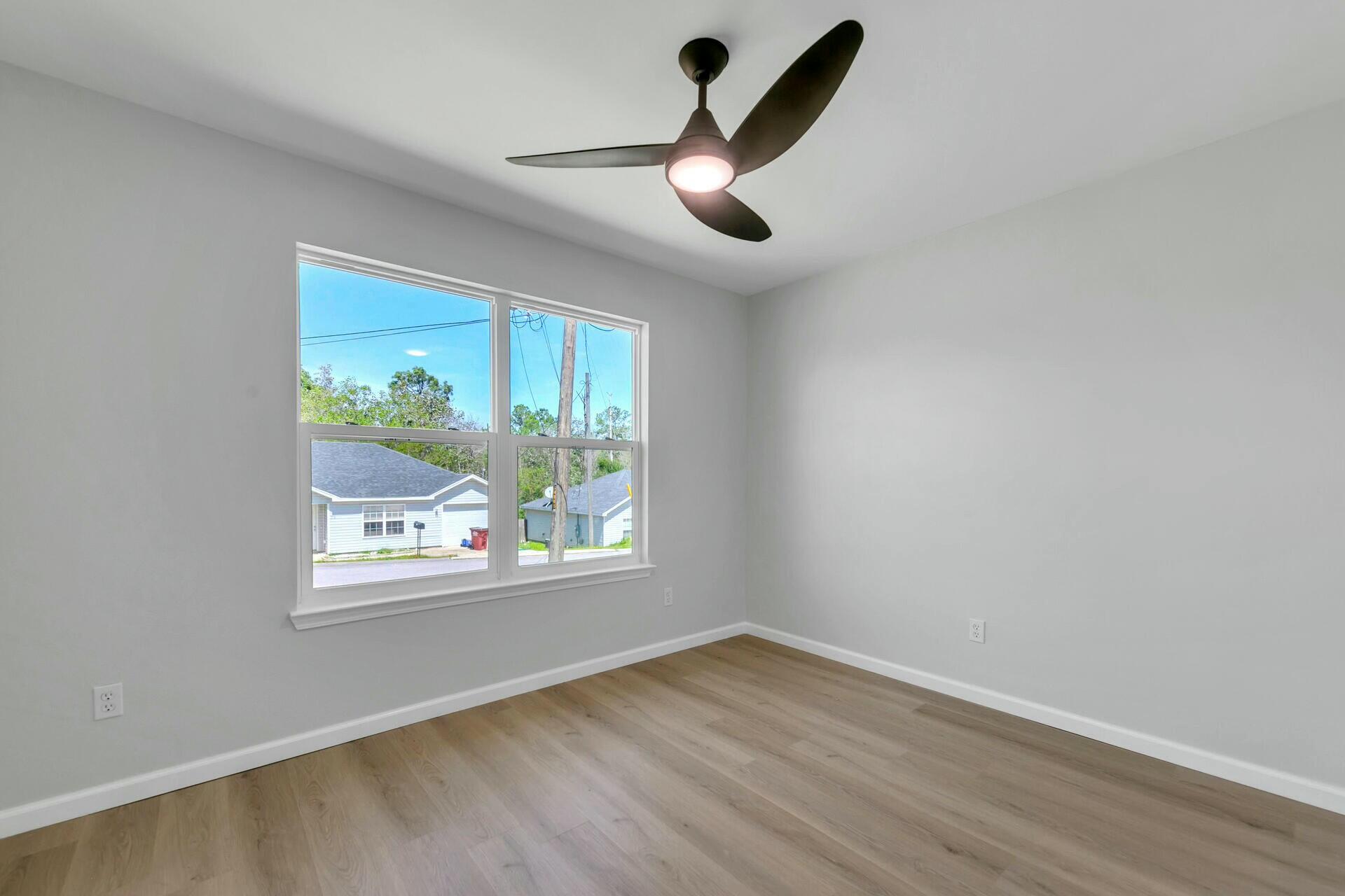 330 Apple Drive Crestview, FL 32536 - Photo 11 of 29 a view of empty room with wooden floor and fan