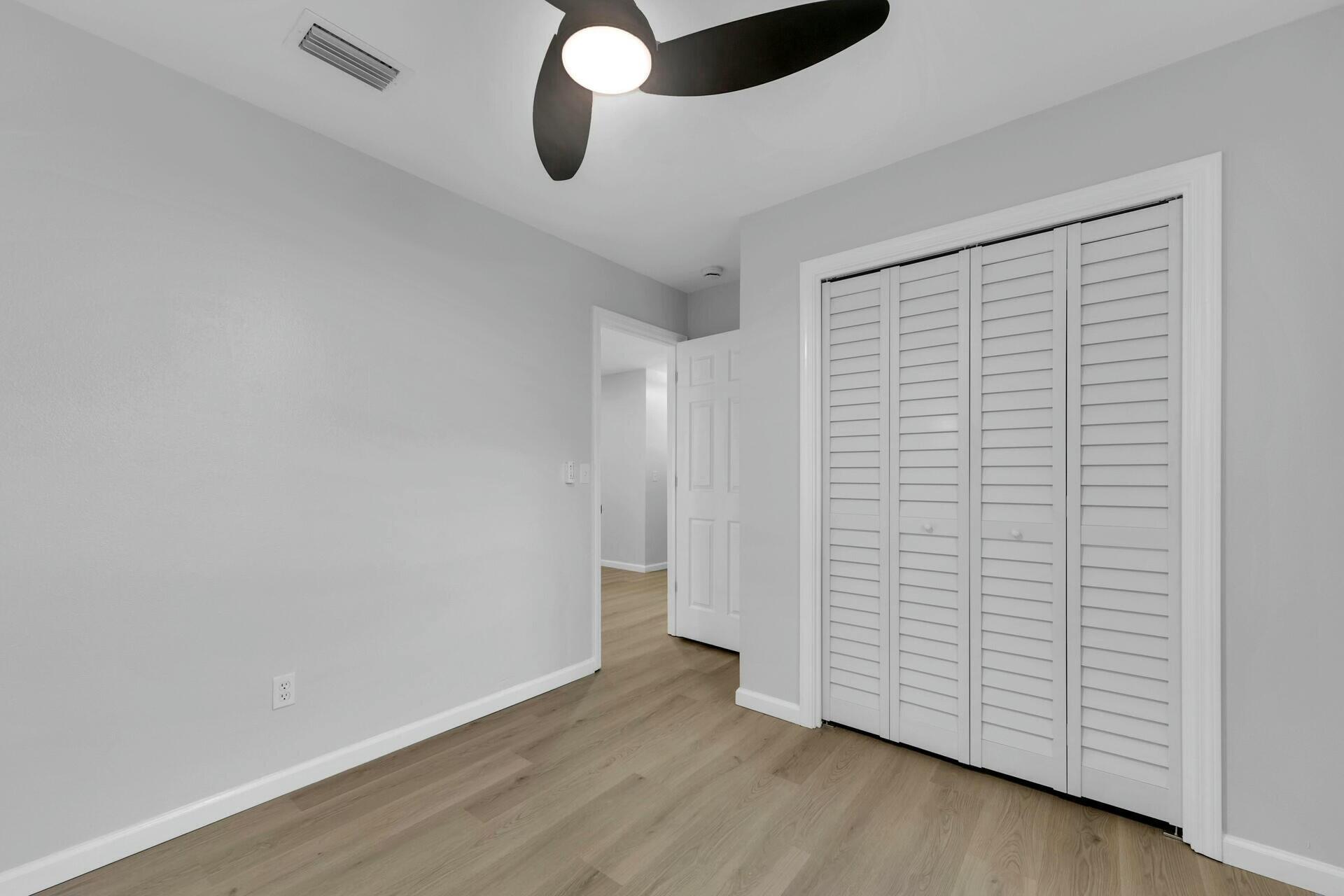 330 Apple Drive Crestview, FL 32536 - Photo 13 of 29 a view of an empty room with wooden floor and a window