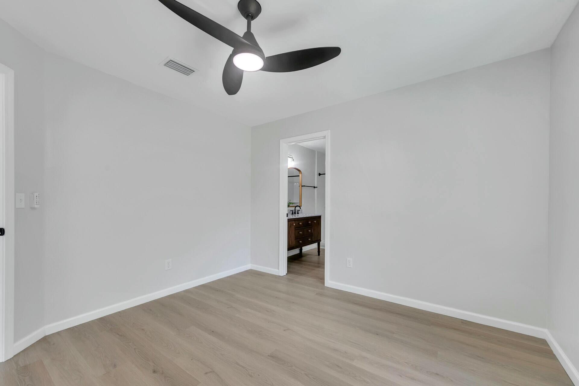 330 Apple Drive Crestview, FL 32536 - Photo 20 of 29 an empty room with wooden floor ceiling fan and windows