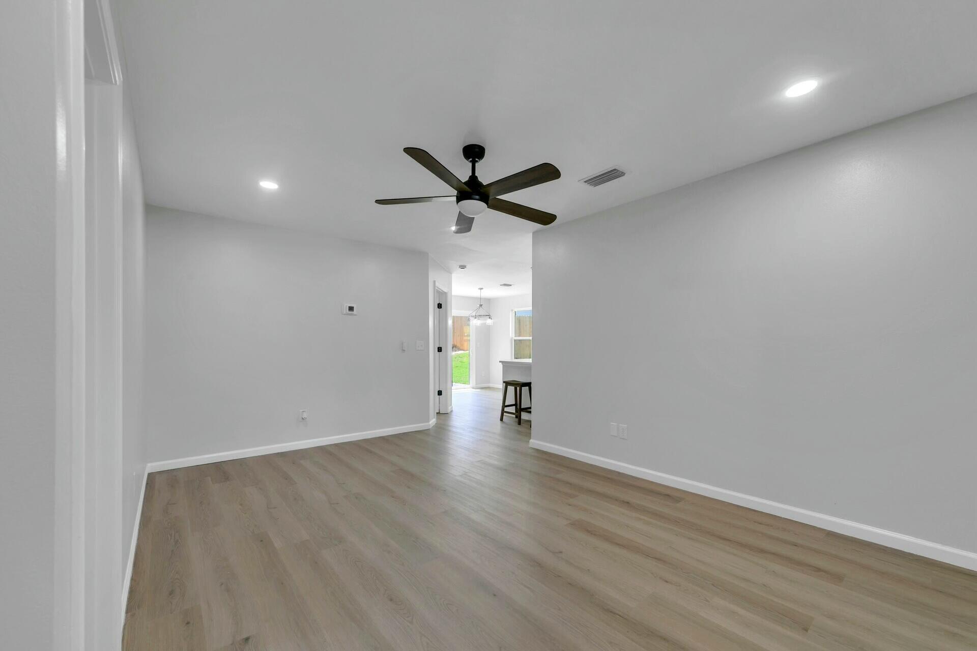 330 Apple Drive Crestview, FL 32536 - Photo 21 of 29 a view of an empty room with wooden floor and a ceiling fan