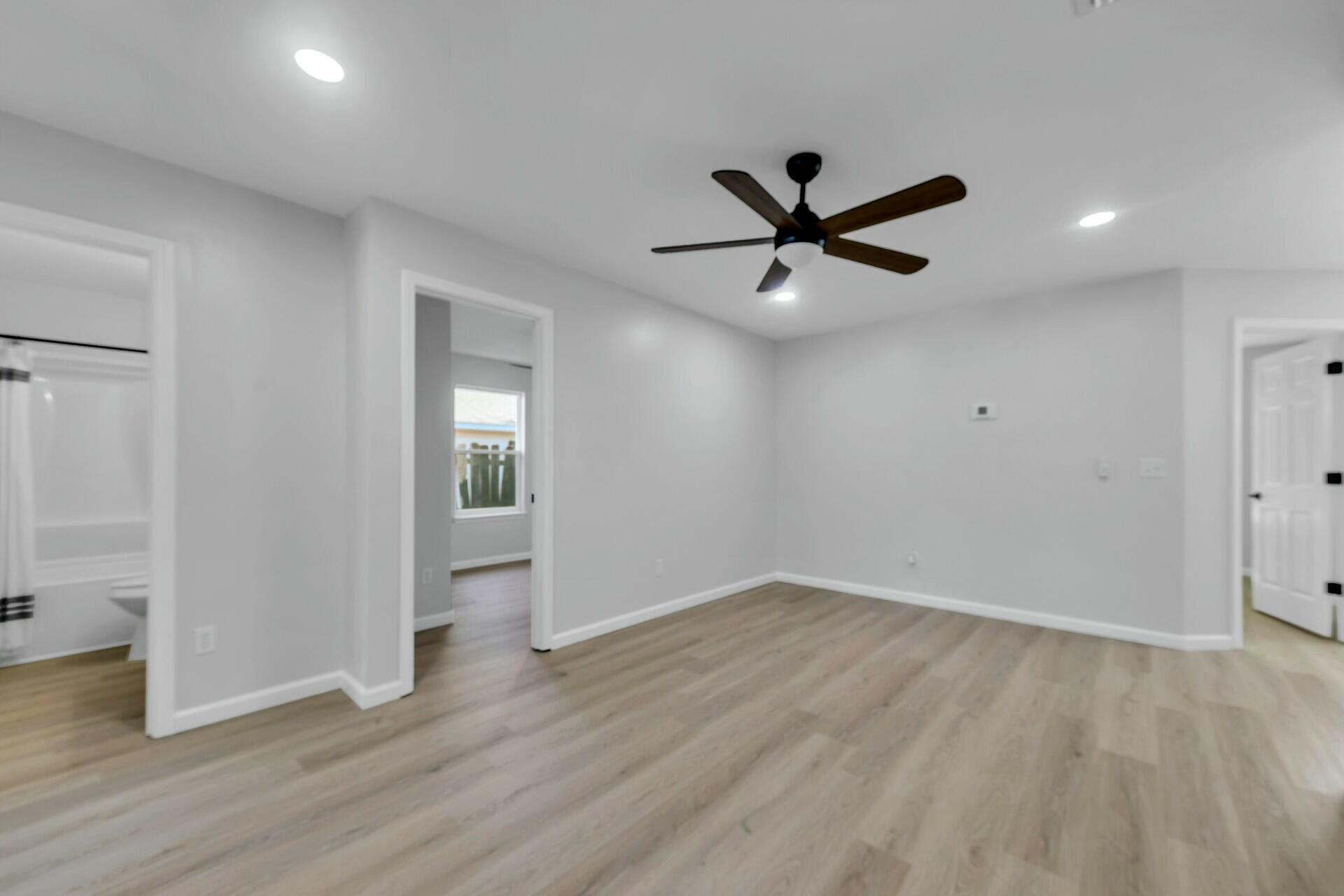 330 Apple Drive Crestview, FL 32536 - Photo 22 of 29 an empty room with wooden floor and a ceiling fan