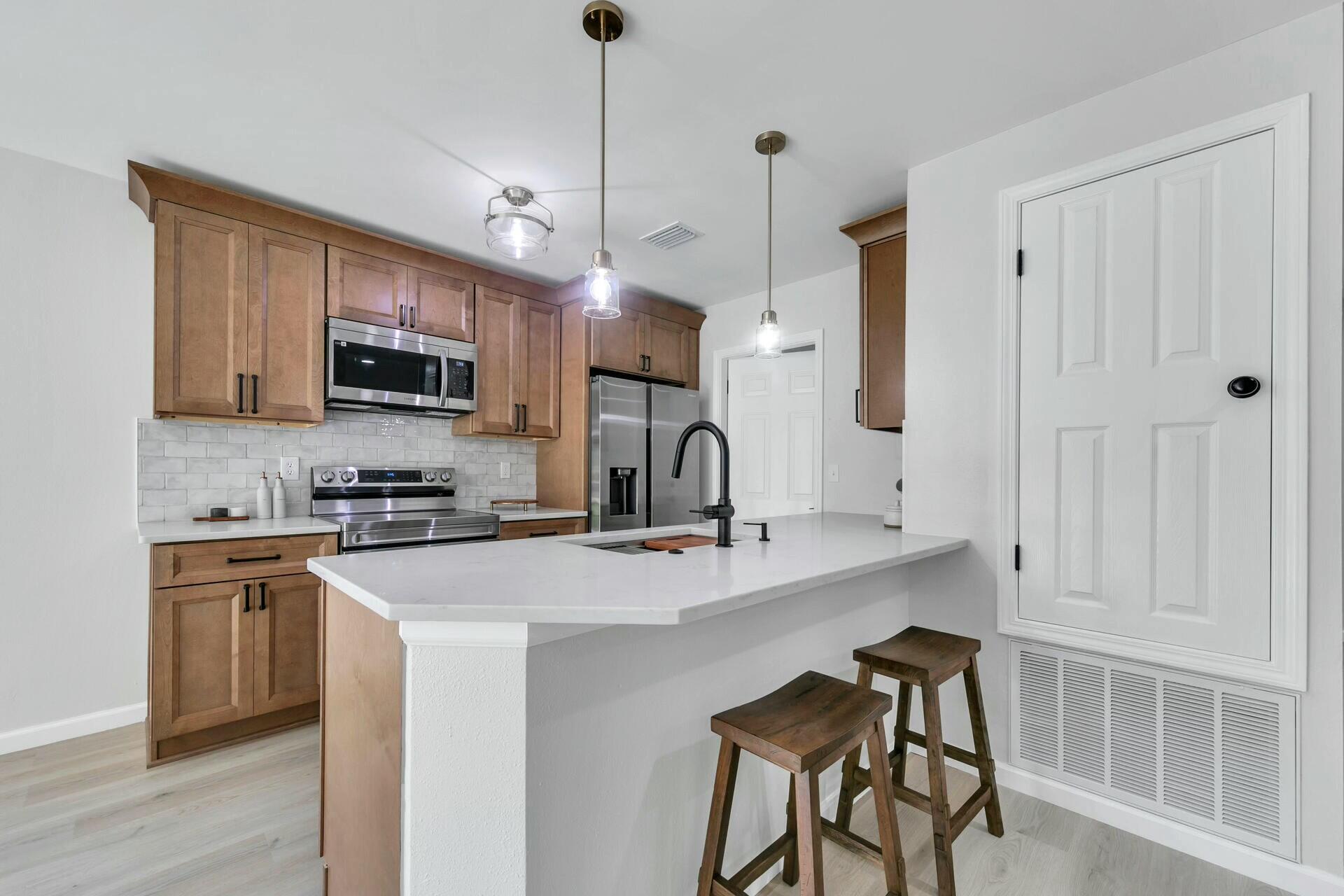 330 Apple Drive Crestview, FL 32536 - Photo 3 of 29 a kitchen with kitchen island a sink stove and microwave