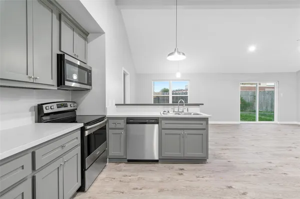 a kitchen with stainless steel appliances granite countertop a stove a sink and a microwave