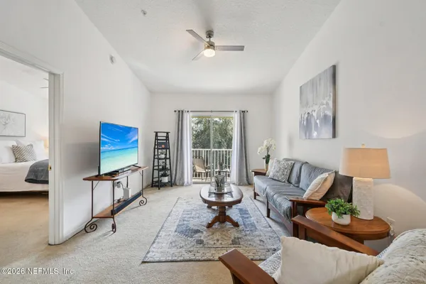 a living room with furniture a rug and a flat screen tv