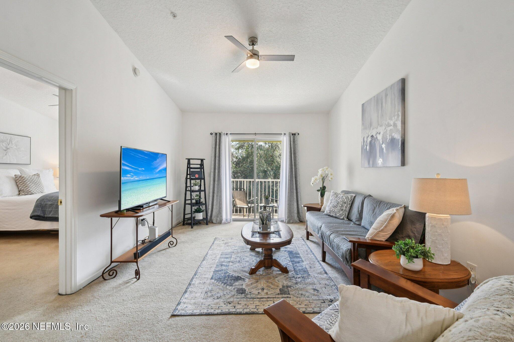 7920 Merrill Road, Unit 1114 Jacksonville, FL 32277 - Photo 1 of 31 a living room with furniture a rug and a flat screen tv