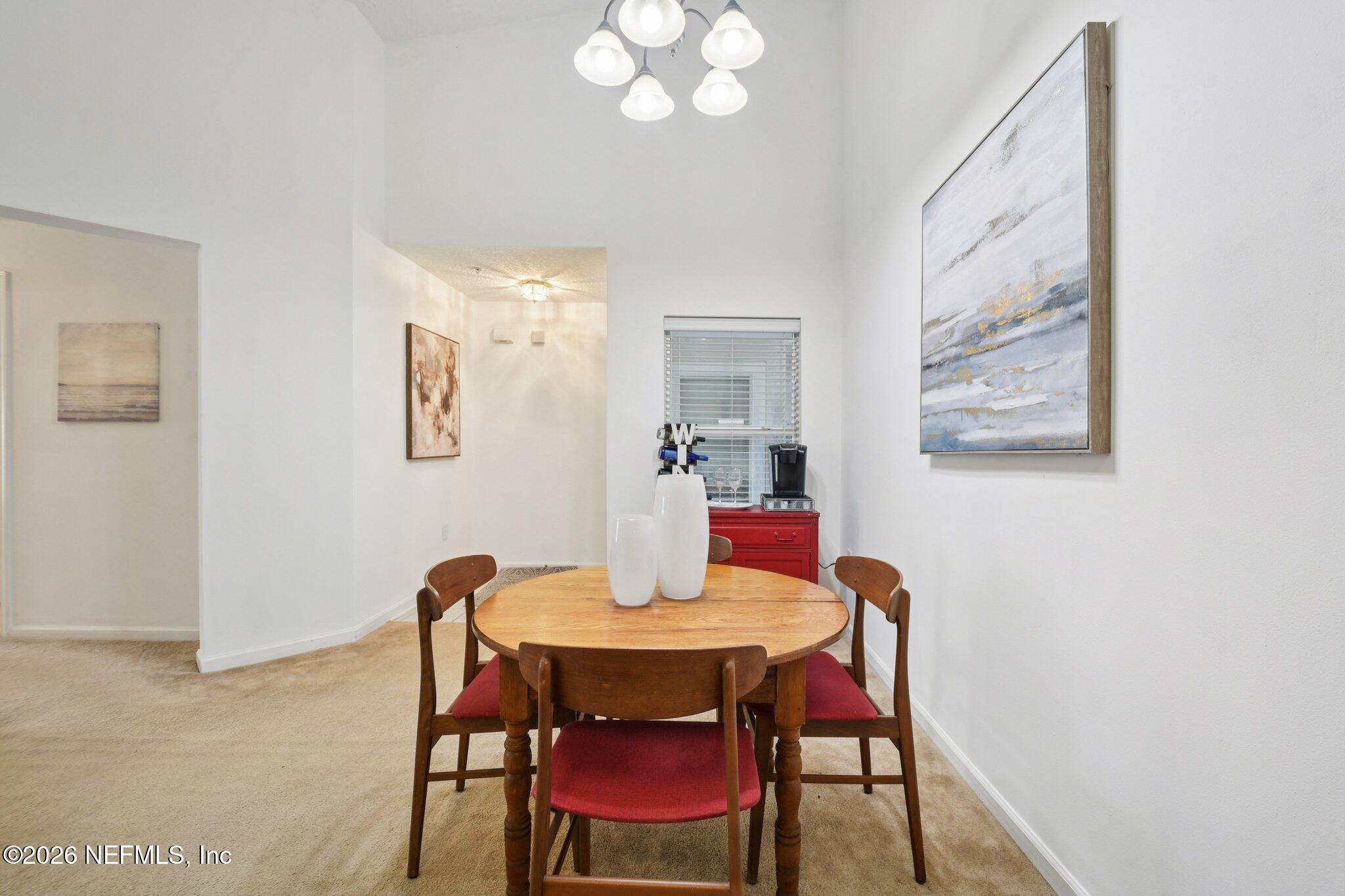 7920 Merrill Road, Unit 1114 Jacksonville, FL 32277 - Photo 13 of 31 a view of a dining room with furniture and wooden floor