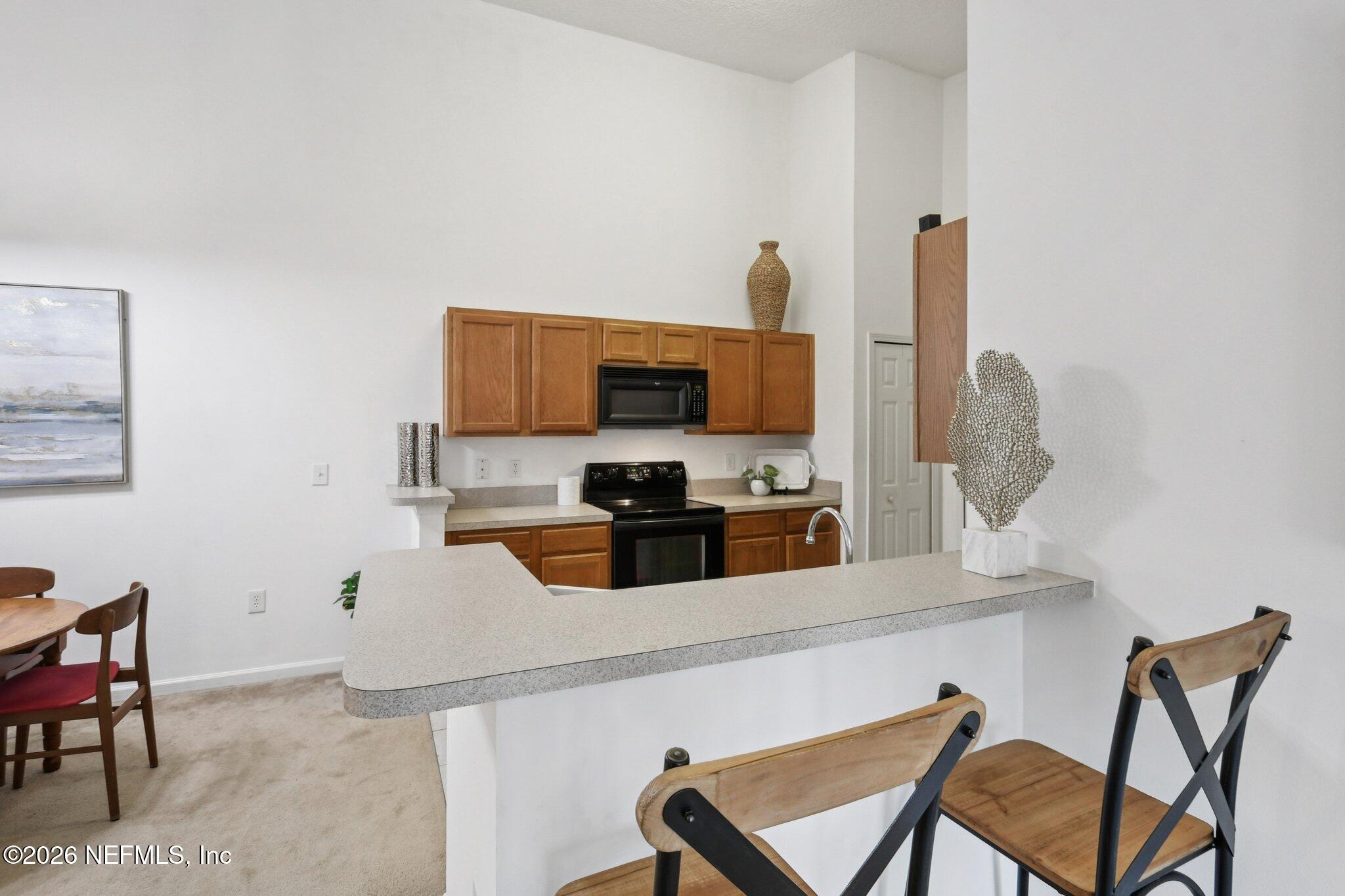 7920 Merrill Road, Unit 1114 Jacksonville, FL 32277 - Photo 17 of 31 a kitchen with stainless steel appliances a microwave and cabinets