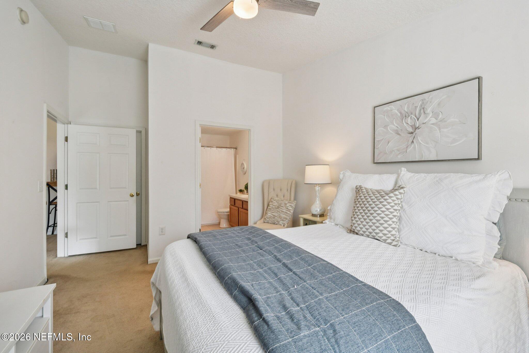 7920 Merrill Road, Unit 1114 Jacksonville, FL 32277 - Photo 20 of 31 a bedroom with a bed and a painting on the wall