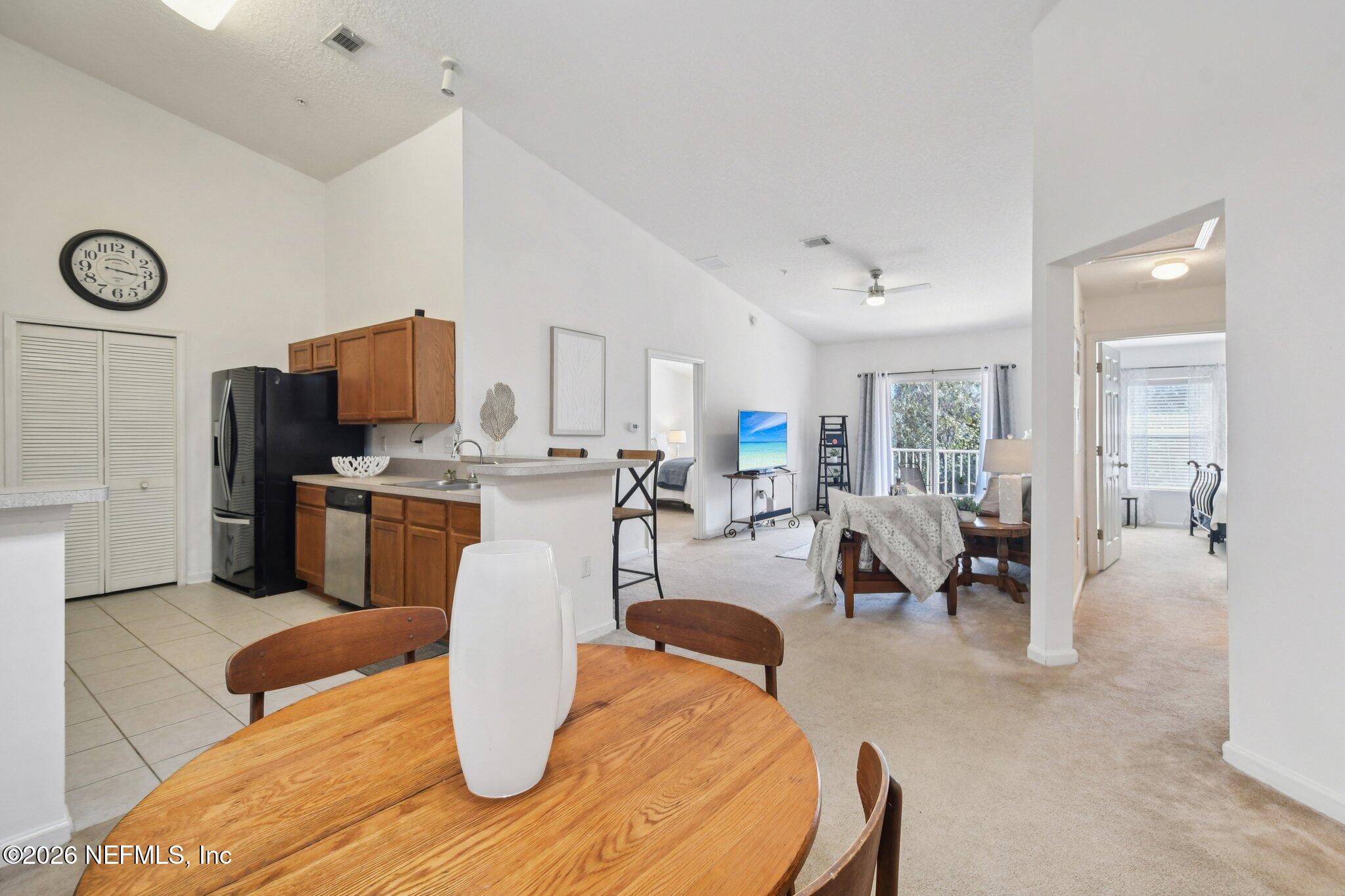 7920 Merrill Road, Unit 1114 Jacksonville, FL 32277 - Photo 2 of 31 a living room with lots of furniture and kitchen view