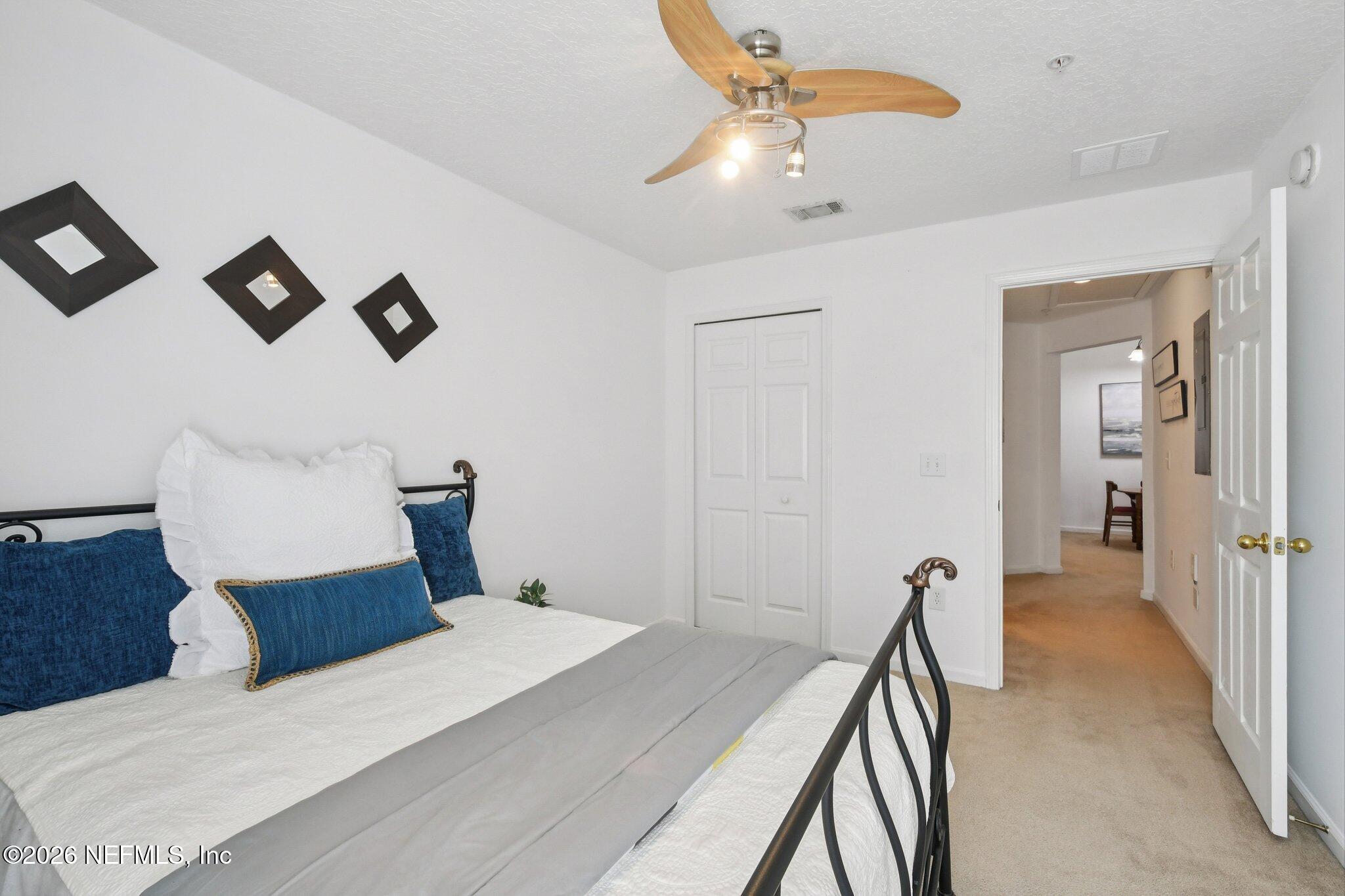 7920 Merrill Road, Unit 1114 Jacksonville, FL 32277 - Photo 24 of 31 a bedroom with a bed and a chandelier