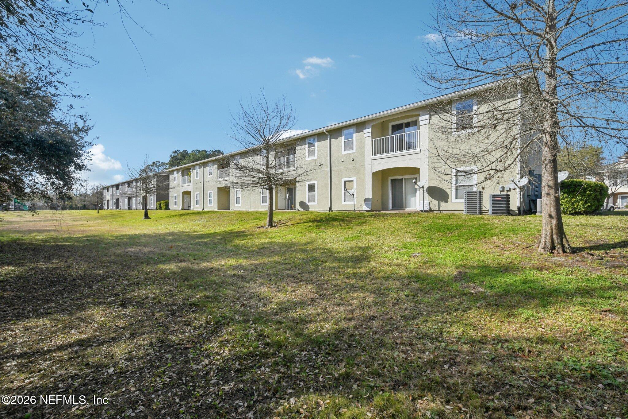 7920 Merrill Road, Unit 1114 Jacksonville, FL 32277 - Photo 27 of 31 a large building with huge green field in front of it
