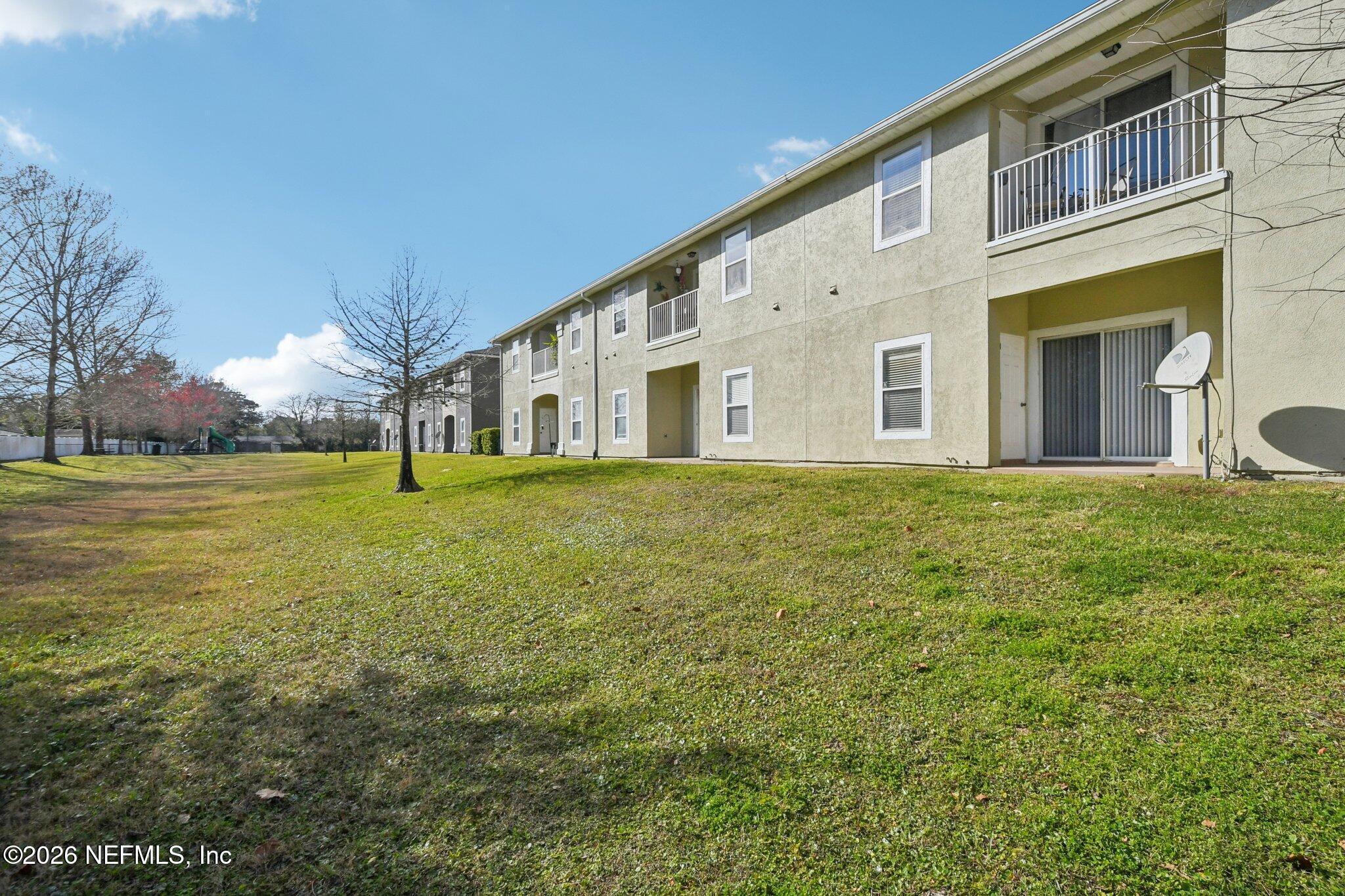7920 Merrill Road, Unit 1114 Jacksonville, FL 32277 - Photo 28 of 31 a large building with a yard